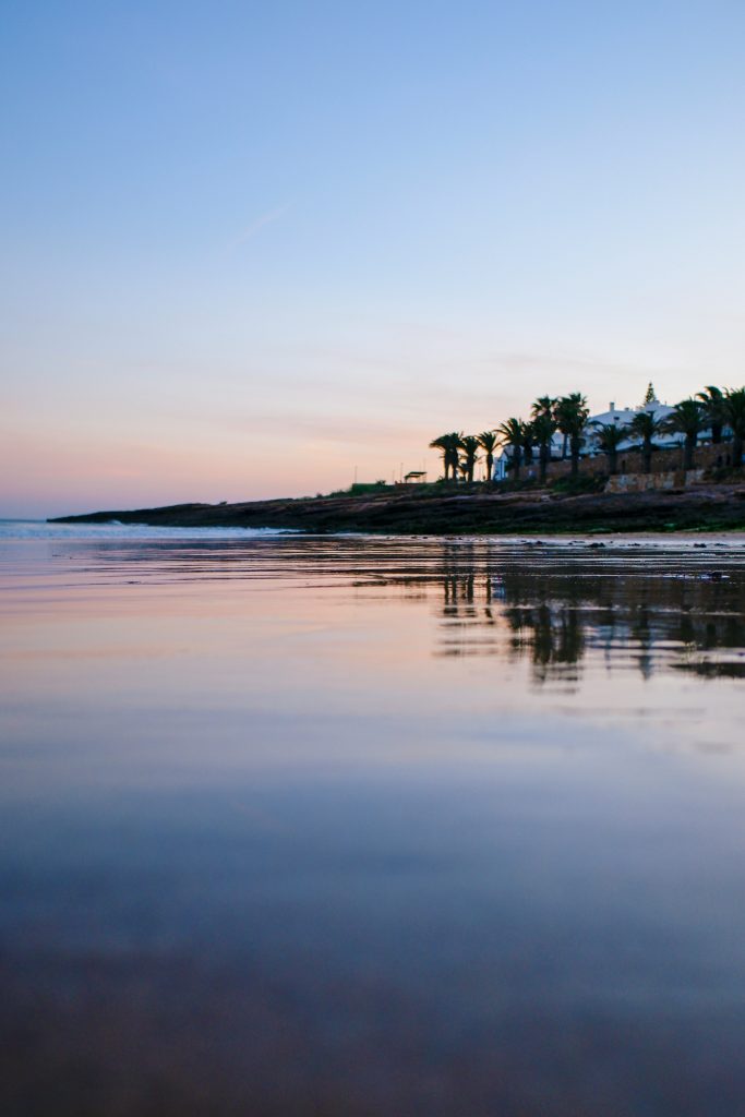 Reflection on the beach, shot during sunset on the Luz boulevard in Portugal.